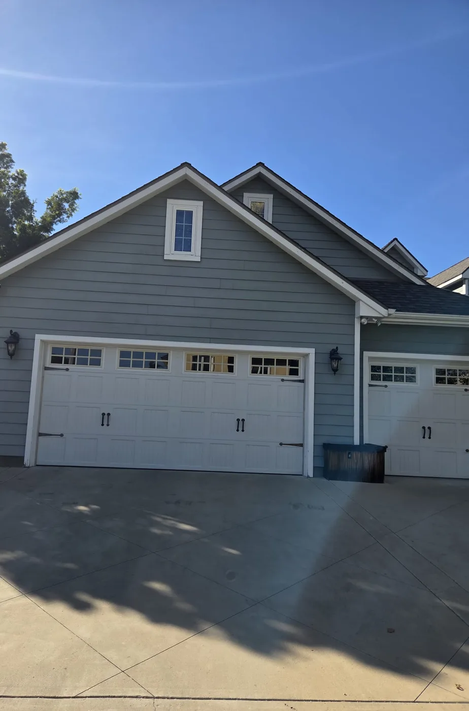 Repainted house exterior with white garage doors